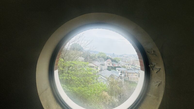 グラバースカイロードの丸窓から見えた街並みと長崎港